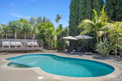 Dive into your private pool surrounded by lush tropical palms and tall cypress trees. Lounge poolside under shaded umbrellas or relax on the elevated deck—your sunny retreat awaits.