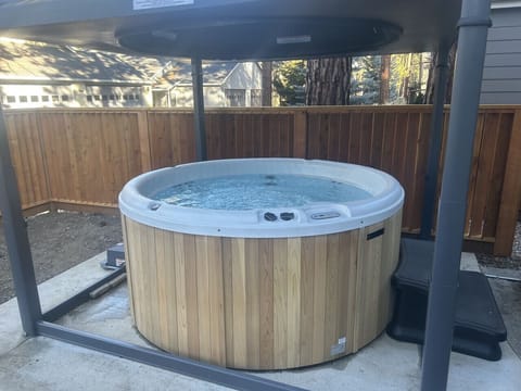 Area around hot tub still in progress, however, this hot tub has a cover that lift up away from the tub with a button and a key.  Lighting above.