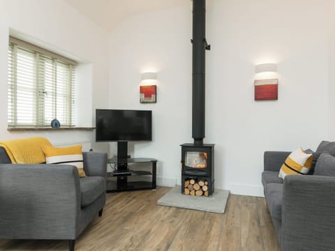 Stylishly furnished living area with cosy wood burner | Blakeskerra Barn, Kenfig, near Porthcawl