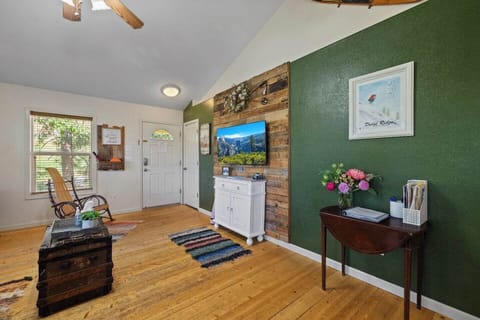 Cozy living room with TV and a unique wood accent wall built from pallet boards. Features keyless entry front door with deadbolt for secure, easy check-in at this Yosemite-area cabin retreat.