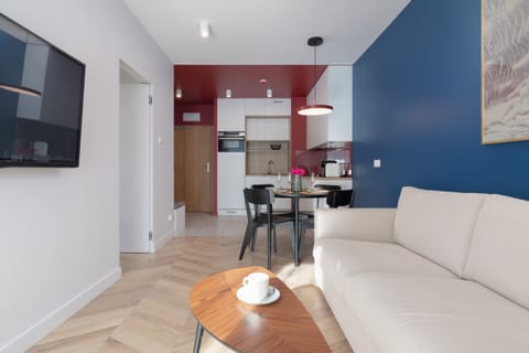 The living room is harmoniously connected to the kitchenette. This is due to the dining area with a table with a round top.