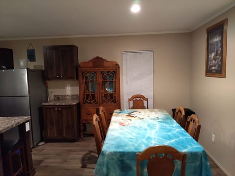 Dining room showing u beach tablecloth, china hutch and side view of kitchen. 🌊