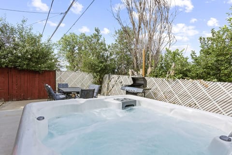 Backyard Bliss Unveiled! - Step into relaxation and culinary delights with a hot tub and grill area in your backyard.