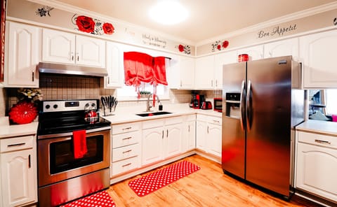 Modern Charm: A Bright and Welcoming Kitchen Accented with Vibrant Red Curtains and Mat 🍽️🔴