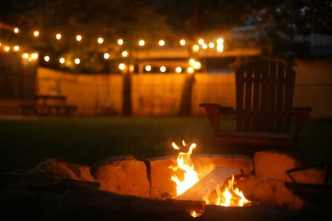Private fire pit with string lights — cozy evenings under the forest canopy.