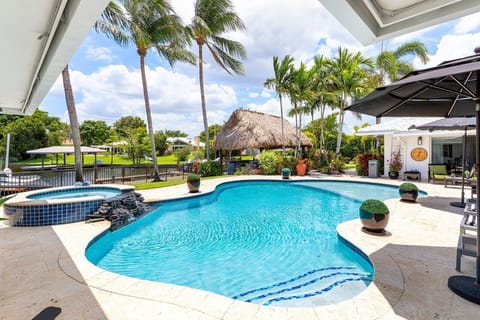 Welcome to your serene backyard oasis, featuring a tranquil setting with lush landscaping, an inviting pool, and a relaxing atmosphere.