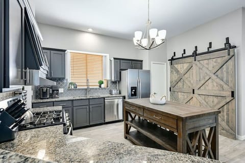 Modern Silverwood kitchen with granite counters, stainless appliances, and rustic barn doors—fully stocked for cooking near The Domain.