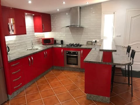 Kitchen area with breakfast bar and two bar stools.