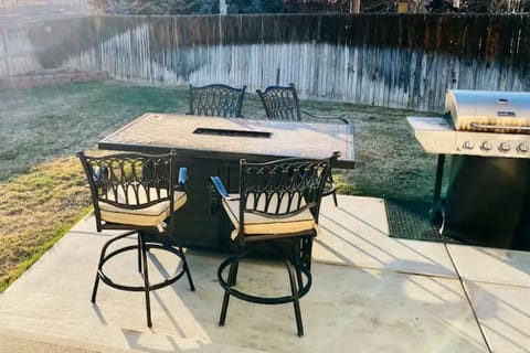 Back yard patio with fire pit table and grill