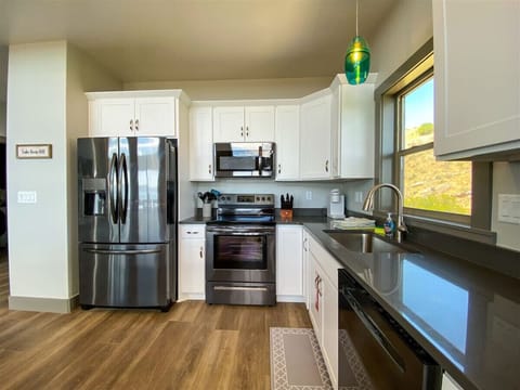 Enjoy cooking with ease in this modern, fully equipped kitchen featuring sleek appliances and scenic views.