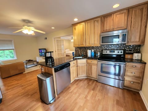 Fully stocked eat in kitchen with breakfast bar, dishwasher, full size fridge.