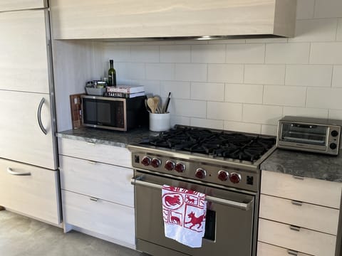 Sleek, modern kitchen features Wolf Range and Sub-Zero fridge