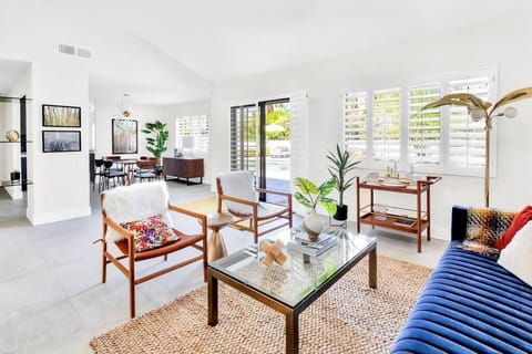 Living room with bar cart, 65" smart TV, Sonos speaker, record player and games.