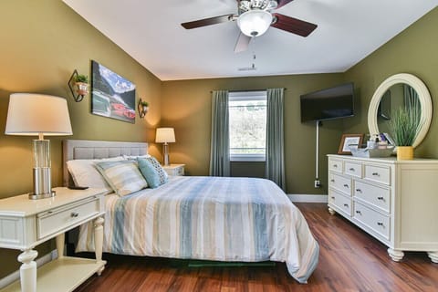 Master bedroom upstairs with queen size bed and mounted TV