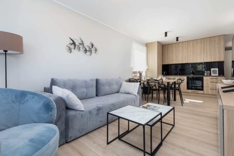 A cozy corner of the living room, with a modern blue sofa and a decorative coffee table.
