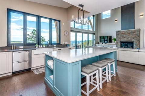 - Spacious kitchen island offers ample prep space, seating, and scenic sightlines
- Soft blue tones, elegant lighting, and four stools create a perfect social hub
- Ideal for morning breakfasts, casual dining, or evening drinks with a view