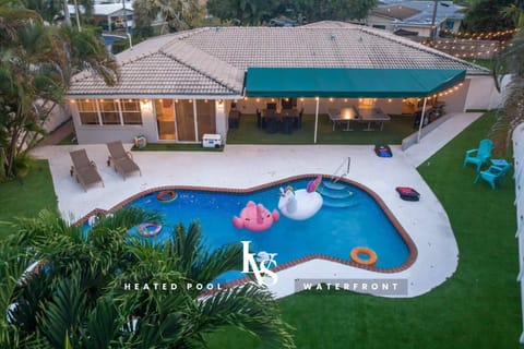 Heated Waterfront Pool in expansive back yard covered in artificial turf, ping pong table, 5 hole putting green, outdoor patio table, 2 kayaks, outdoor TV, BBQ Grill & separate Blackstone griddle.