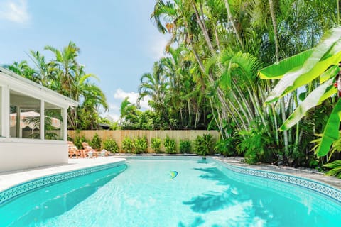 Escape to paradise with a private resort-style pool, lush tropical landscaping, and a shaded tiki hut—your perfect backyard retreat.