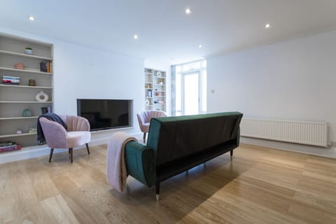 Comfortable living room with large HD TV, sofa bed and comfy chairs