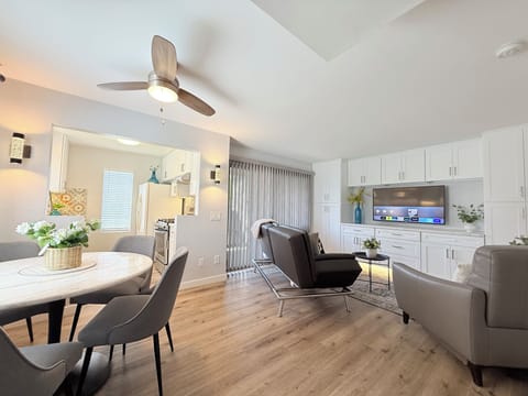 Living room with custom built-ins, a smart TV, cozy seating including a sofa bed