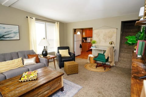 Living room with a desk for working and the stairs to the upstairs