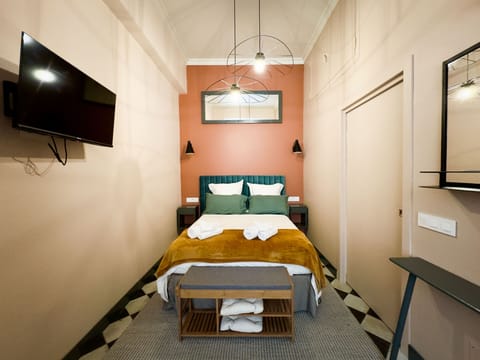 Comfortable bedroom with a plush double bed and a pop of color, ideal for a restful night after a day at the beach.