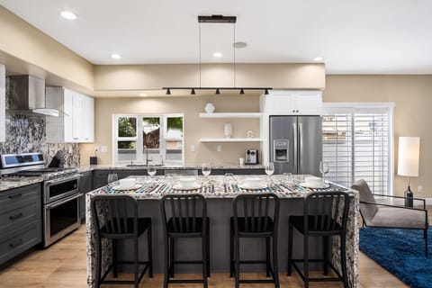 Additional bar seating for four people in the kitchen. The ice maker does not work, but there are ice trays.