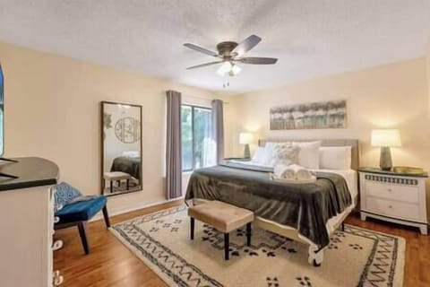 The primary bedroom boasts a King-size bed, full-size mirror, and seating area.