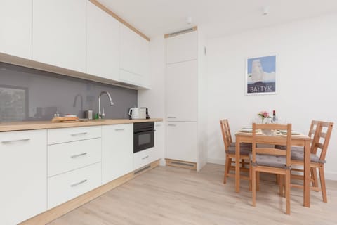 A kitchen with white cabinetry, a built-in oven, and ample counter space, blending functionality with a simple aesthetic.
