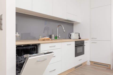 A kitchen with white cabinetry, a built-in oven, and ample counter space, blending functionality with a simple aesthetic.
