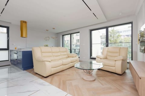 Bright living room with white leather sofa set, large windows let in plenty of natural light, emphasizing the unique character of the room.