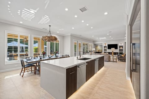 Open floor plan with kitchen, formal dining and living room overlooking the grounds.