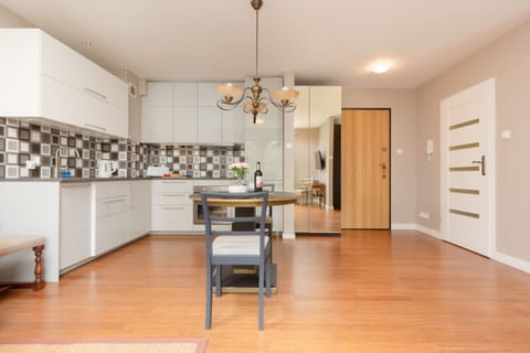 The dining room is set up with a large dining table, chairs, and decorative chandelier lighting.