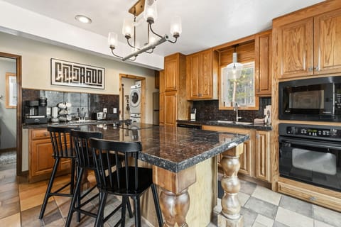 Cook your favorite meals in this spacious kitchen featuring granite countertops, custom wood cabinetry, and modern appliances for your comfort.