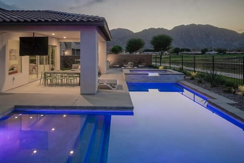 Evening poolside glow w/ covered dining area & mountain backdrop