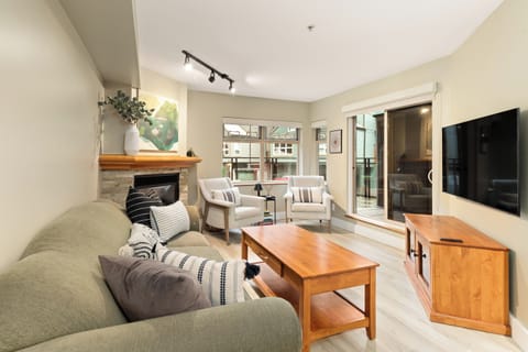 Bright open-concept living area with fireplace and access to private patio