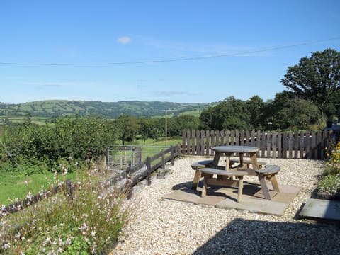 Gravelled patio with picnic-style table and chairs | Dairy Cottage - Carmarthen Cottages, Cwmdu, Near Llandeilo