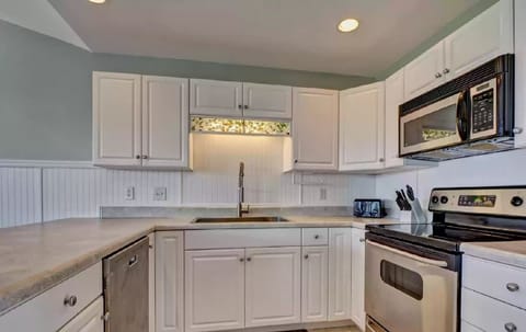 Kitchen with microwave, dishwasher, disposal, stove and refrigerator.