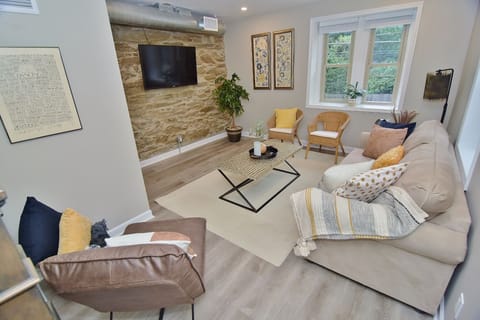 A warm and inviting living room featuring a stunning stone accent wall and plenty of comfortable seating for gathering with family and friends