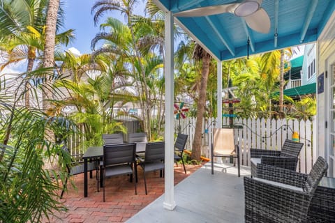 The back patio boasts an outdoor dining area, additional seating, and string lights.