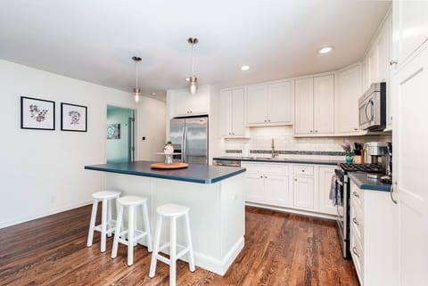Kitchen with large island, seating for 3, drip coffeemaker, and Keurig