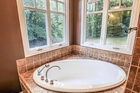 tub in bathroom attached to primary bedroom