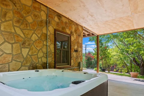 The hot tub is located just outside the game room in the peaceful backyard area.