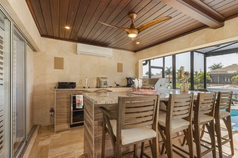 Outdoor bar and grill area feature two mini refrigerators and Bluetooth speaker.