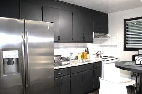 Kitchen features an electric stove/oven, Keurig coffee machine, microwave, dishes, pots and pans and nice large fridge.