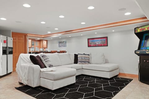 Basement family room with vintage arcade game, bar, and darts.