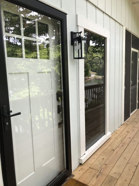 Side deck & front entry. Door to screened in deck with furniture & ceiling fans