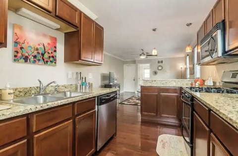 Kitchen includes dishwasher, microwave, and other stainless steel appliances.