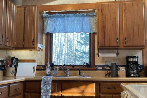 Enjoy a well-outfitted kitchen! Wash dishes at the sink with a view into the woods.