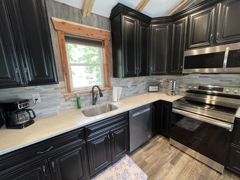 Kitchen is stocked with dishes, glasses, spices, cooking utensils